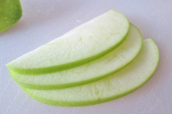 Разрезать дольками зеленое яблоко